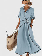 Détail du col V contrasté et détail torsadé de la robe longue