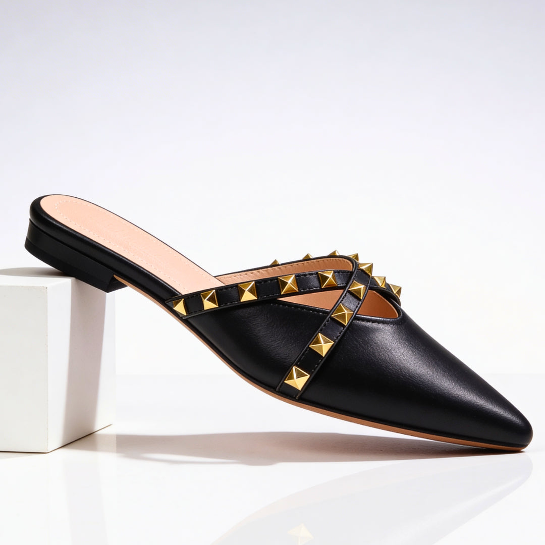 Mules cloutées portées de profil, silhouette pointue
