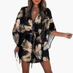 Femme portant la robe mini imprimé feuilles tropicales, vue de face