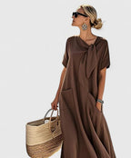 Femme portant une robe maxi marron fluide avec col noué