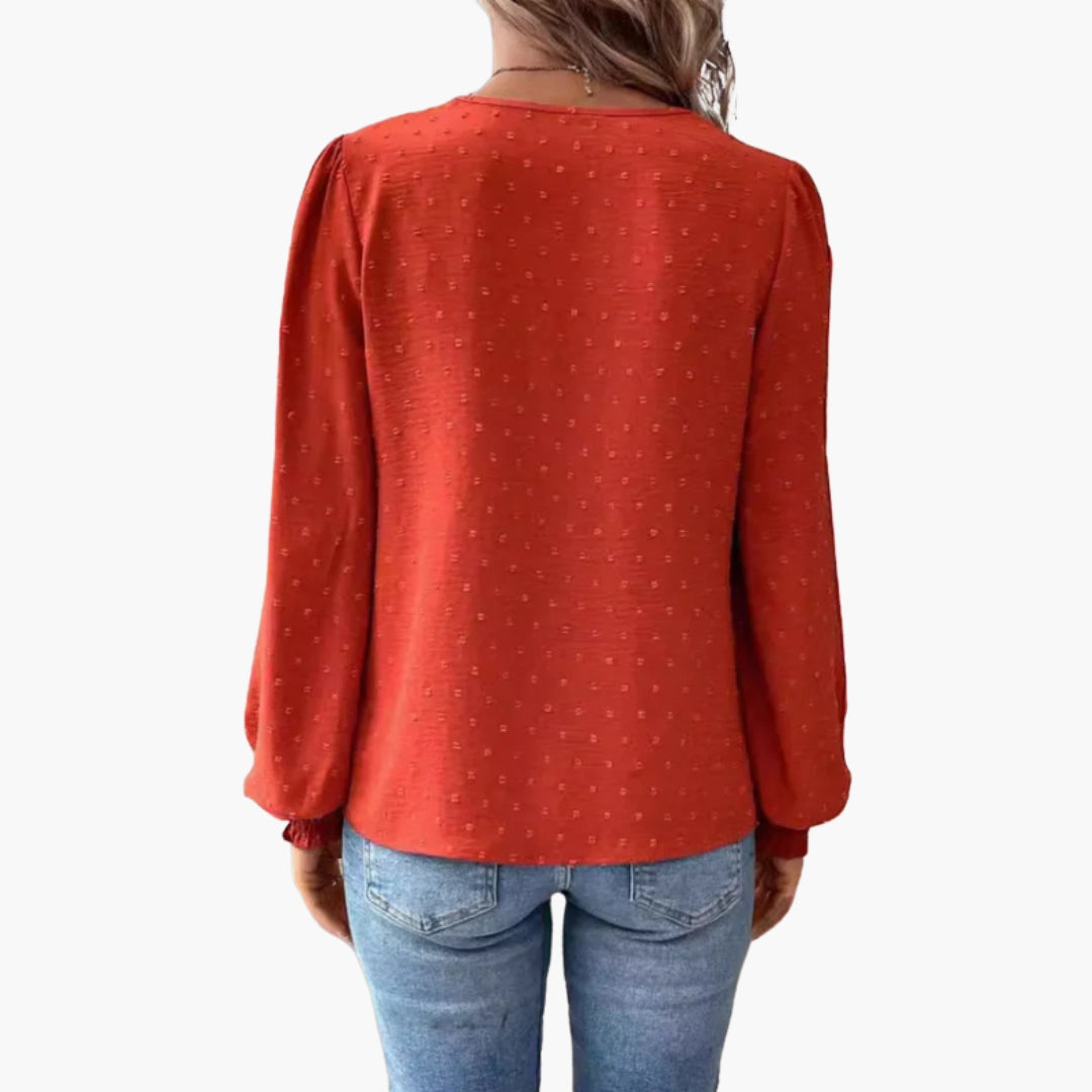 Détail de la dentelle brodée au col en V de la blouse