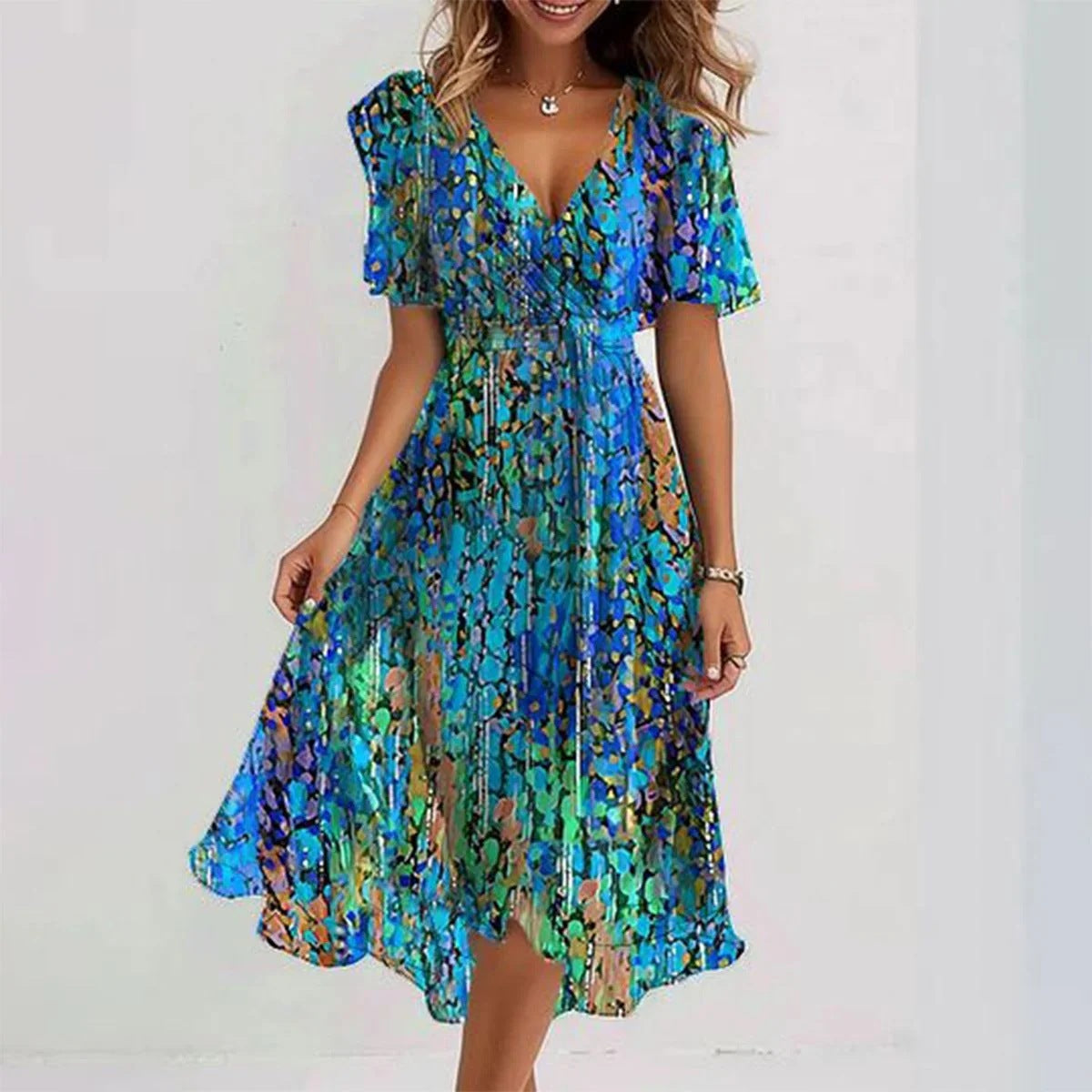Femme de dos portant la robe midi verte à fleurs, ourlet asymétrique visible
