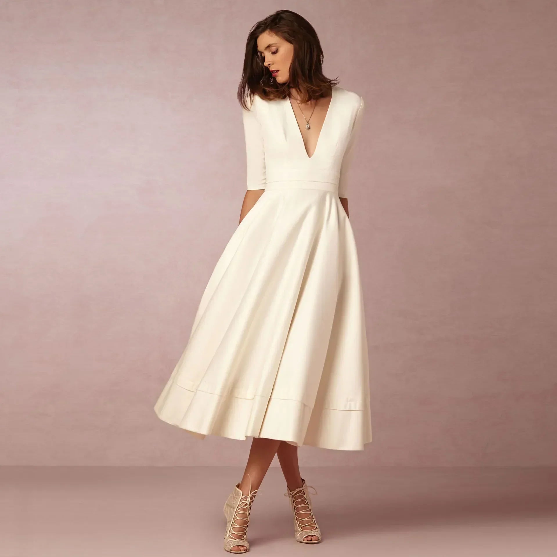 Femme portant une robe midi ivoire évasée col V manches trois-quarts, vue de face