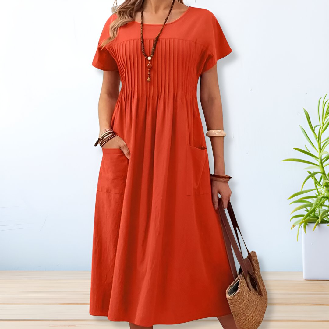 Femme portant la robe midi, détail du panneau plissé frontal